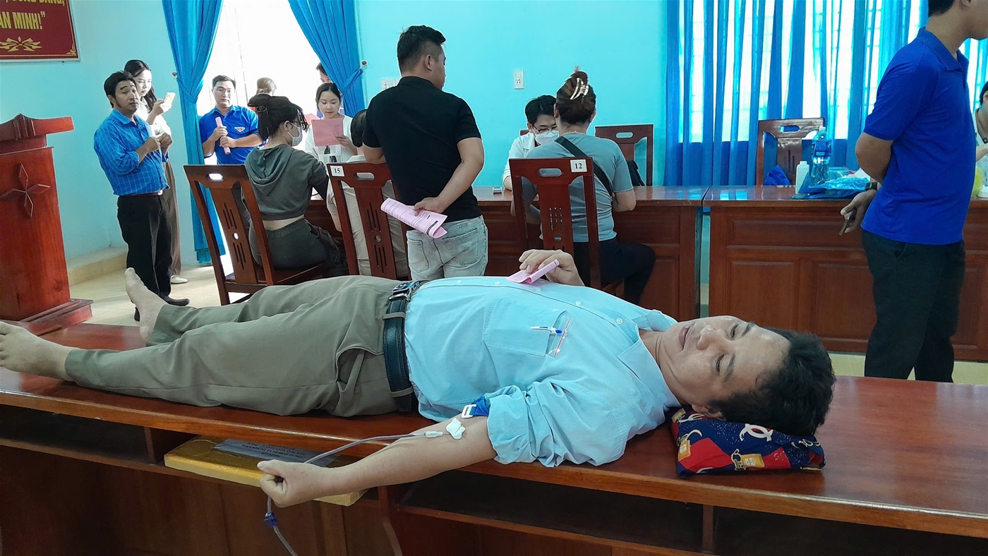 Description: A person lying on a desk with a device in his handDescription automatically generated