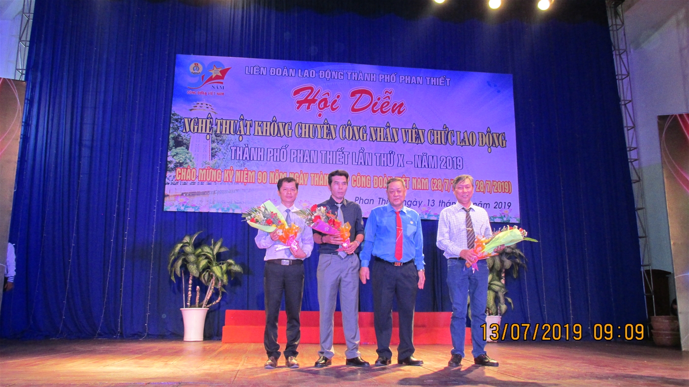 Ảnh: Ông Võ Huy Luận – Trưởng Ban Tổ chức tặng hoa cho Ban Giám khảo Hội diễn